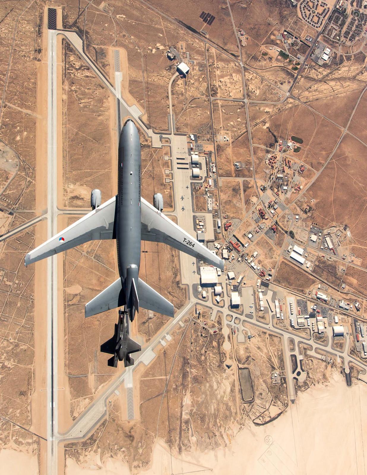 An aerial view of a plane flying over a desert air base.