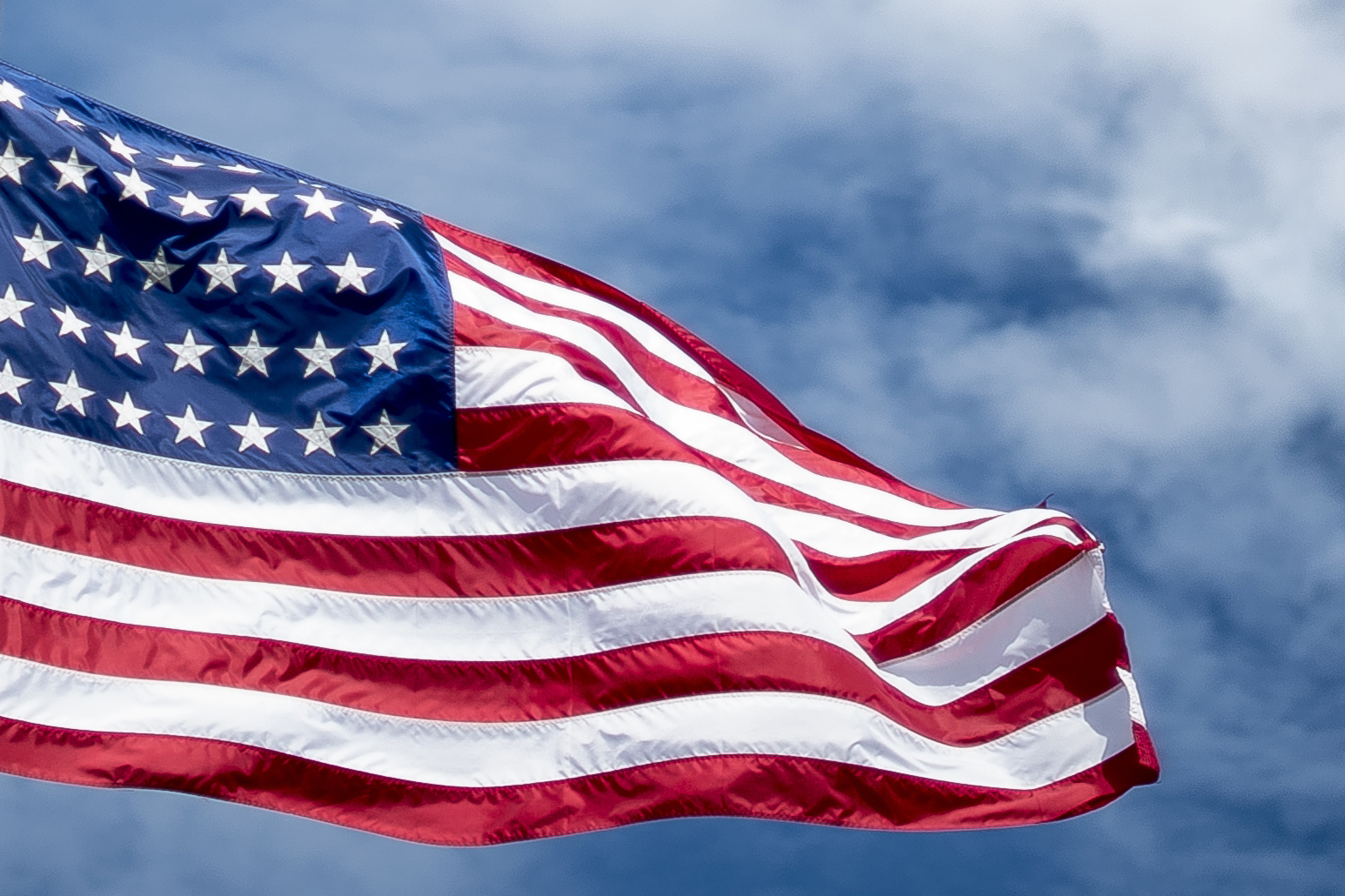 US flag waving against blue sky